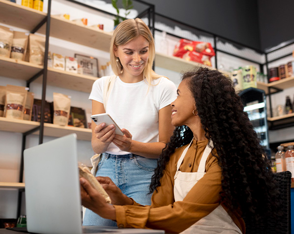 Duas mulheres ajustando o valor do produto no computador